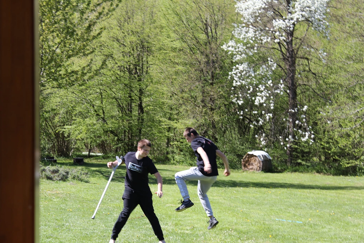 Two participants moving on a meadow at the edge of a forest