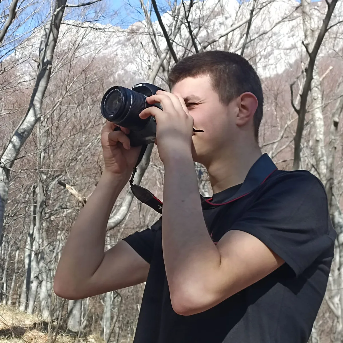 A participant taking a photo with a camera in the forest