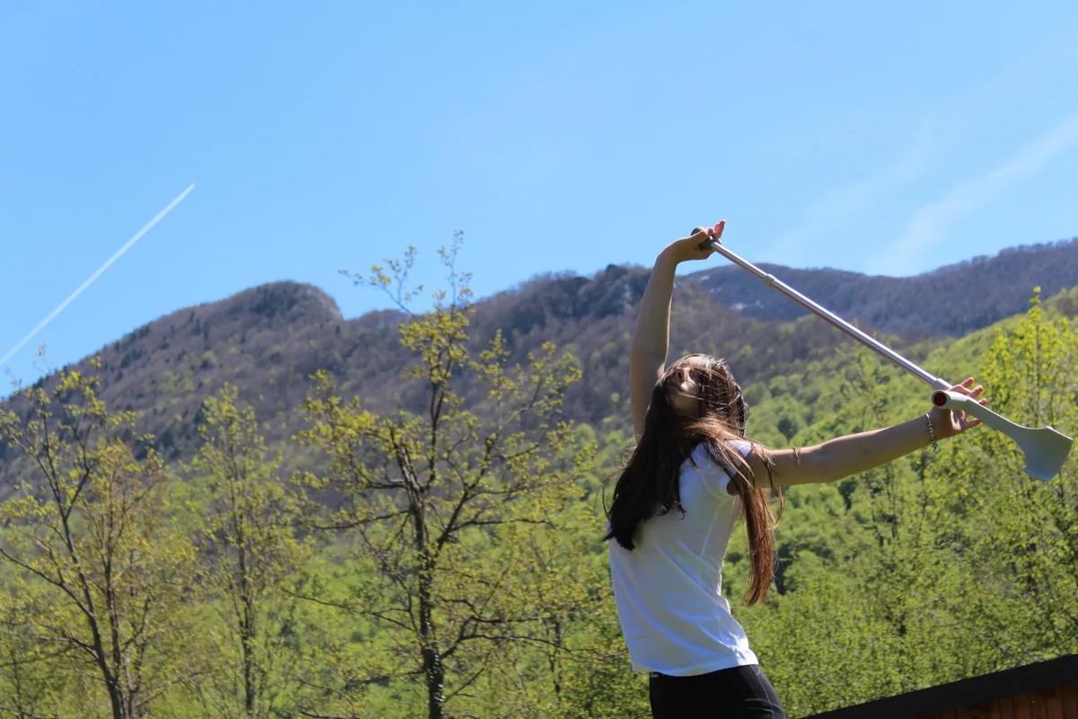 A participant moving with a crutch raised towards the sky, outdoors